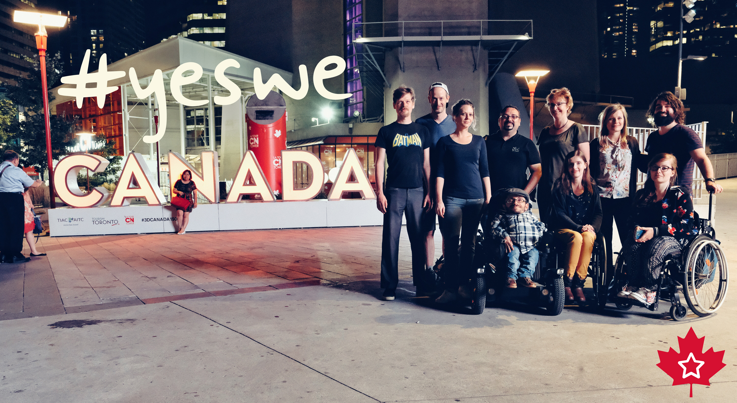 Das Sozialhelden-Team steht vor einem Canadaschild und darüber steht "yes we"