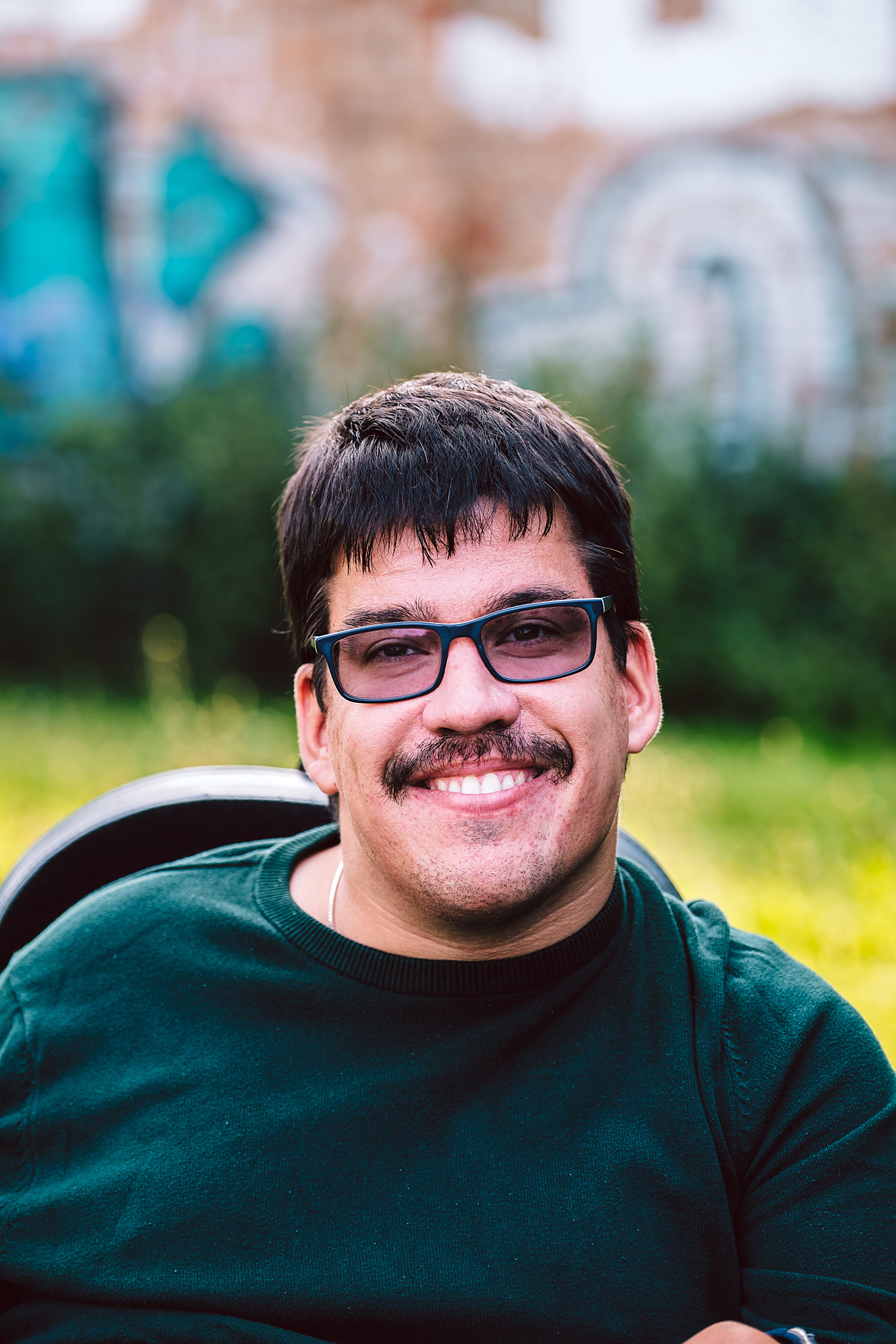Porträtfoto von Sven Papenbrock. Er trägt einen grünen Pulli, eine Brille und lächelt in die Kamera.